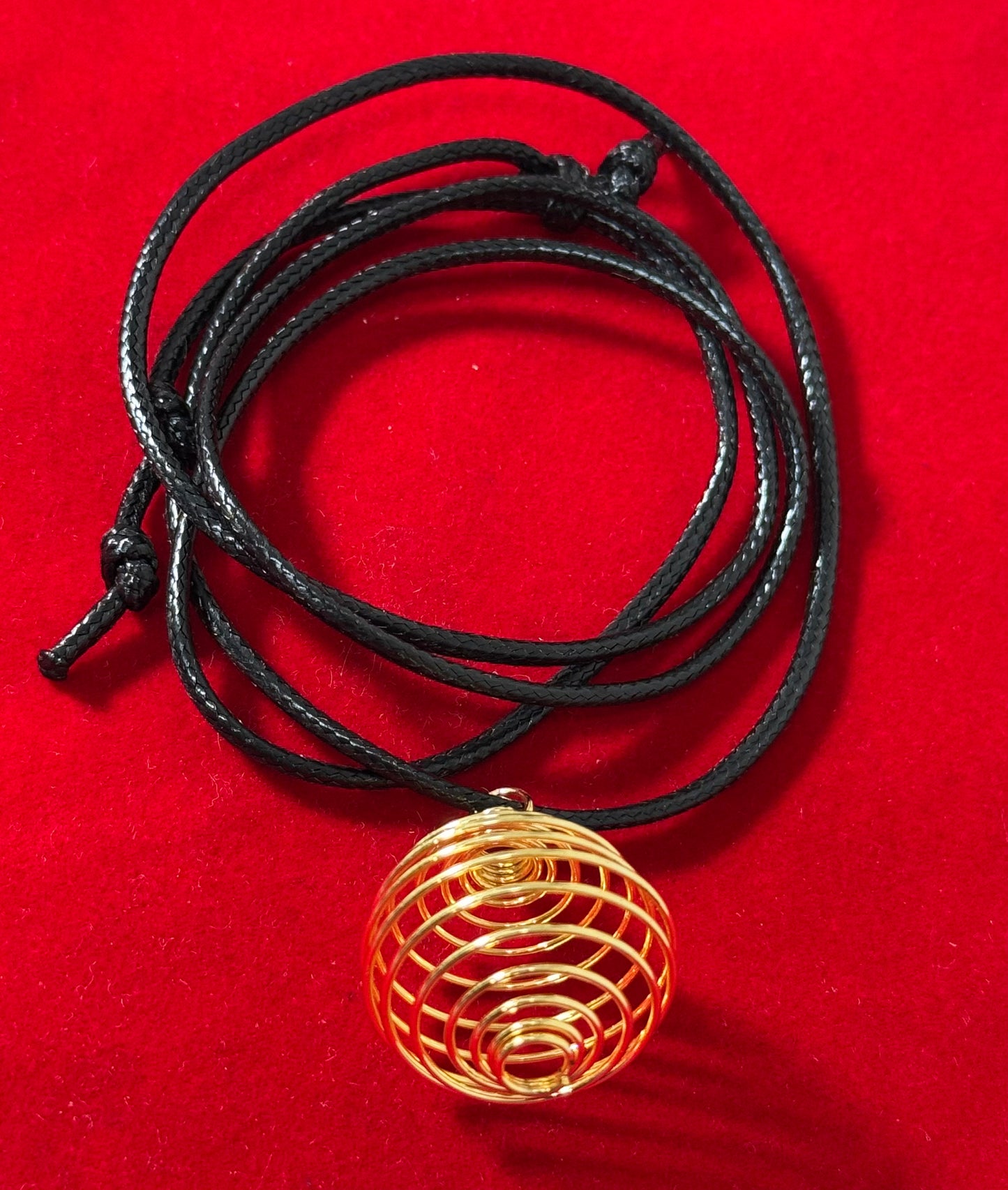 Gold Plated Round Cage with Black Cord – stylish round cage pendant with gold plating, suspended on a black cord necklace.