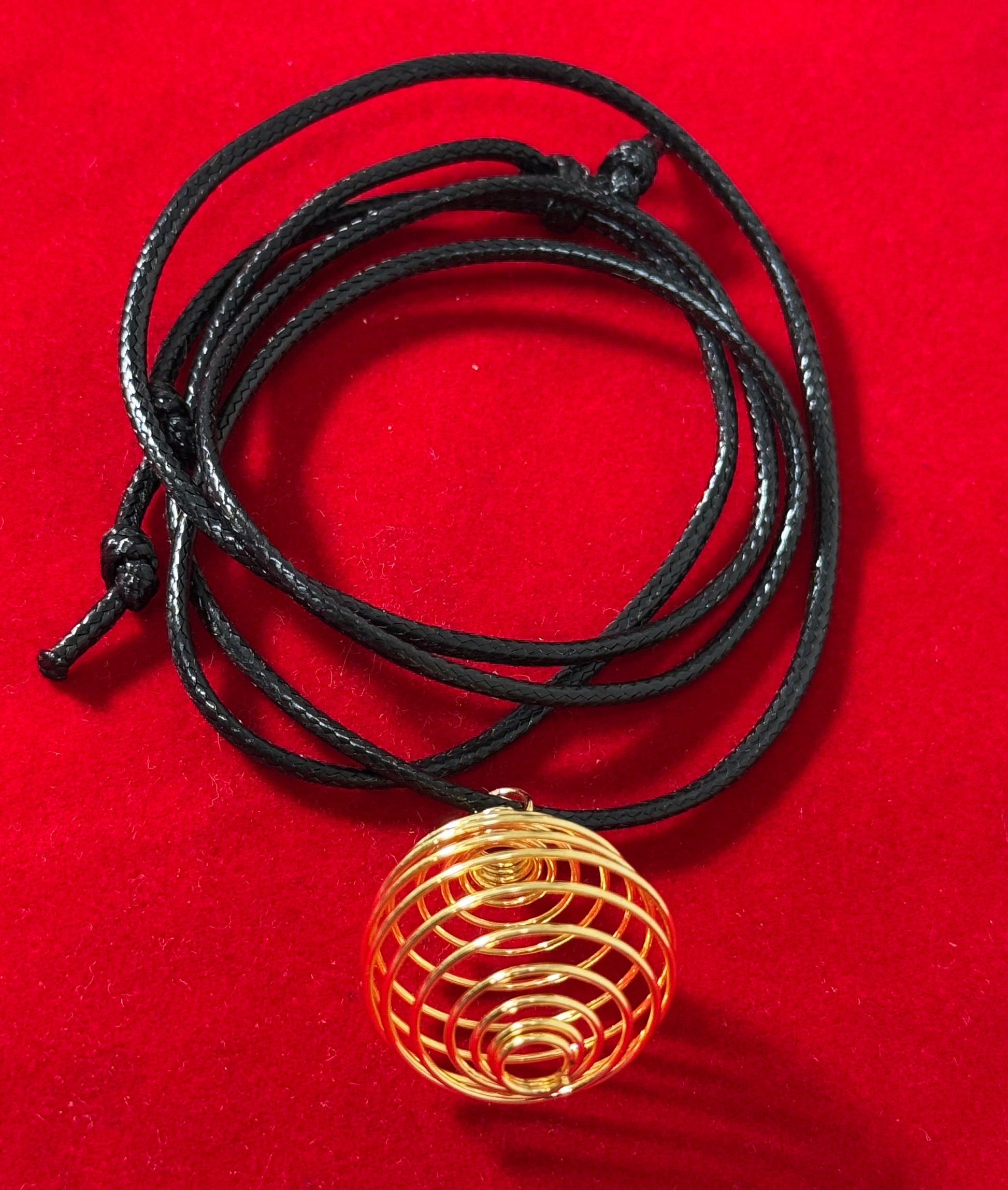 Gold Plated Round Cage with Black Cord – stylish round cage pendant with gold plating, suspended on a black cord necklace.
