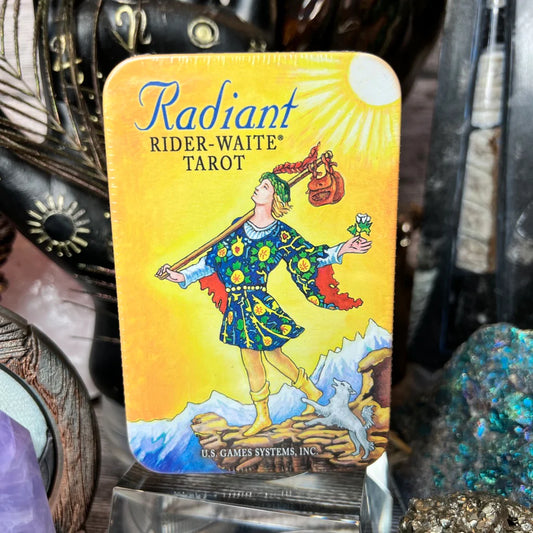 Radiant Rider-Waite Tarot in a Tin by Pamela Colman Smith – 78-card deck featuring vibrant, enhanced colors and subtle shading, housed in a compact tin box with a starry sky design on the back of the cards.
